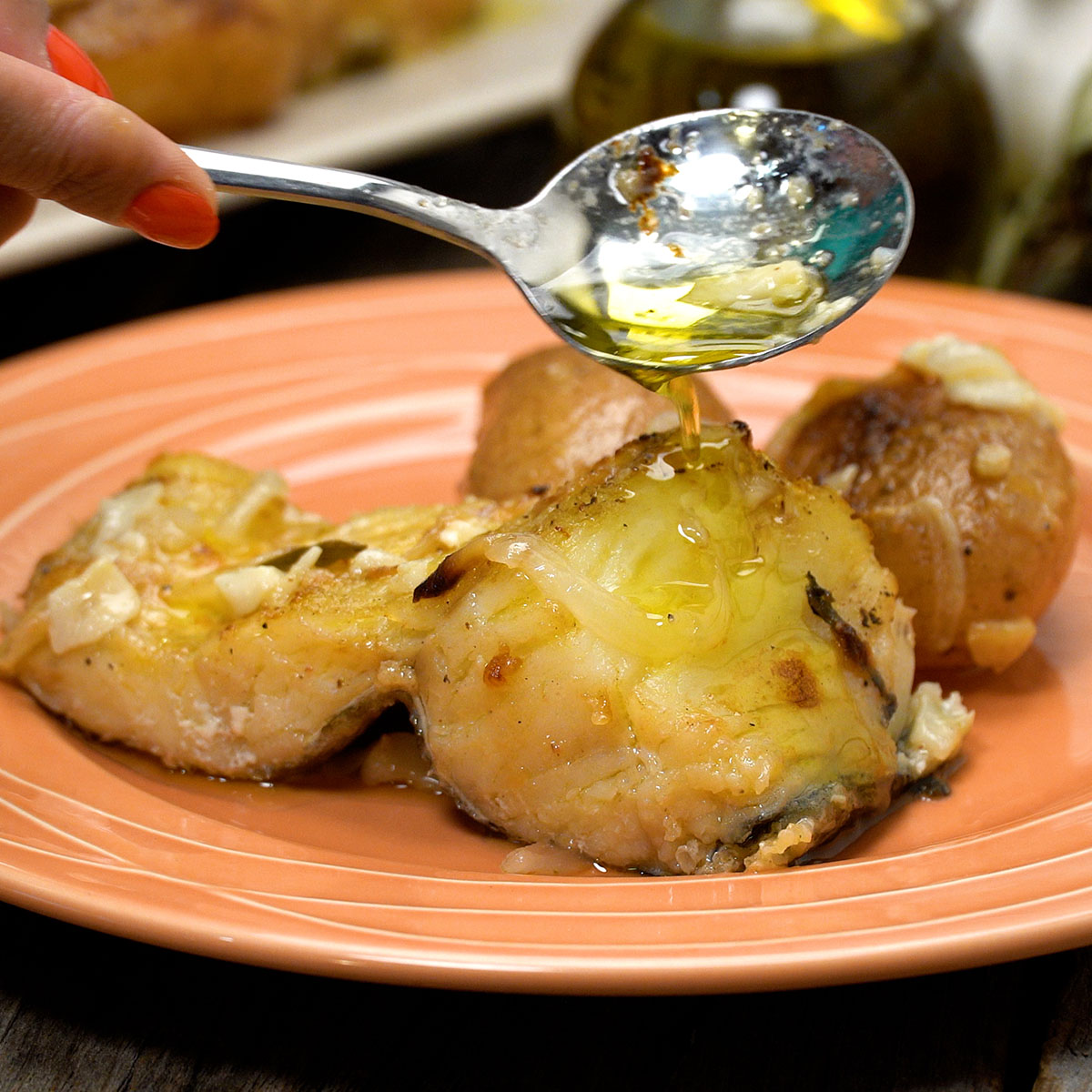 Bacalhau assado servido no prato e regado com azeite quente e alho dourado
