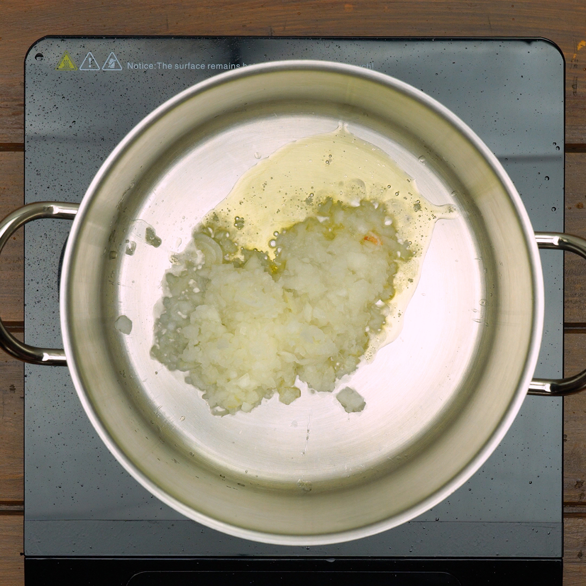 Cebola e alho picados sendo refogados em azeite aromatizado para base do caldo verde