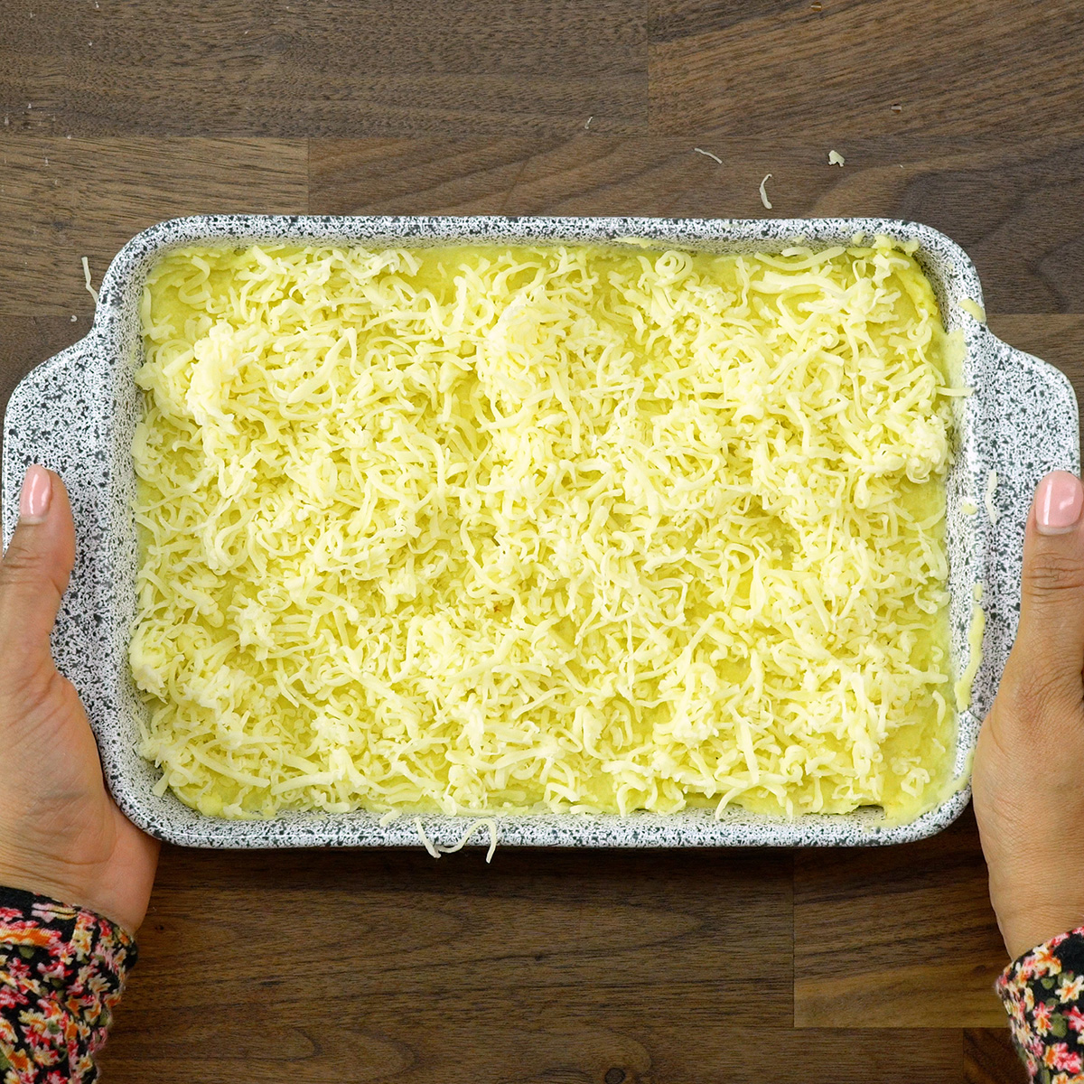 Escondidinho de carne moída sendo levado ao forno para gratinar.
