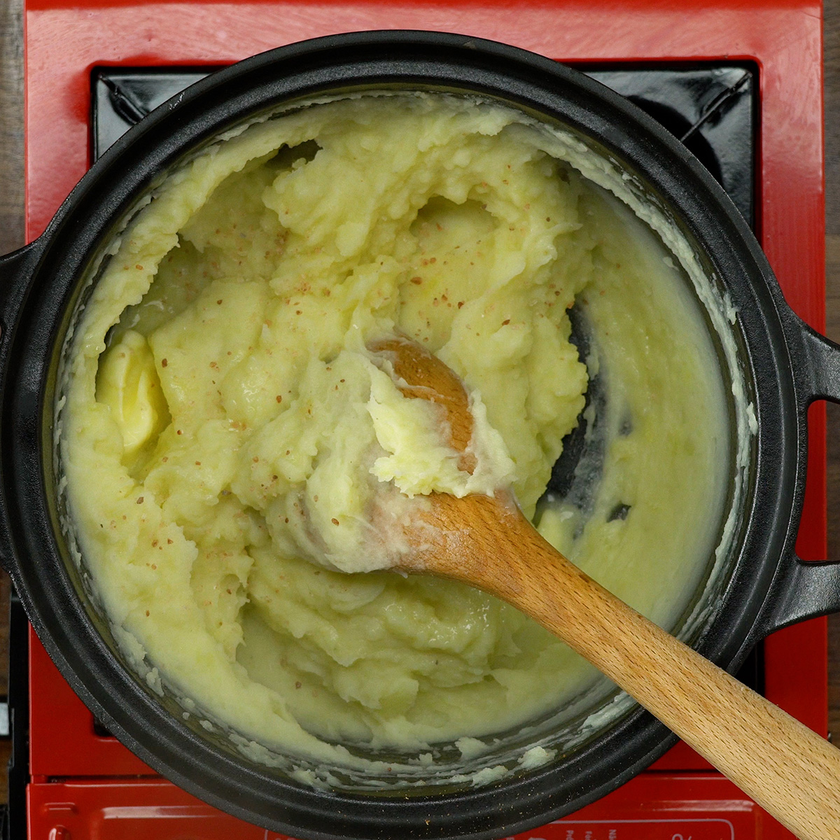 Temperando o purê de batata com sal, pimenta, manteiga e queijo.