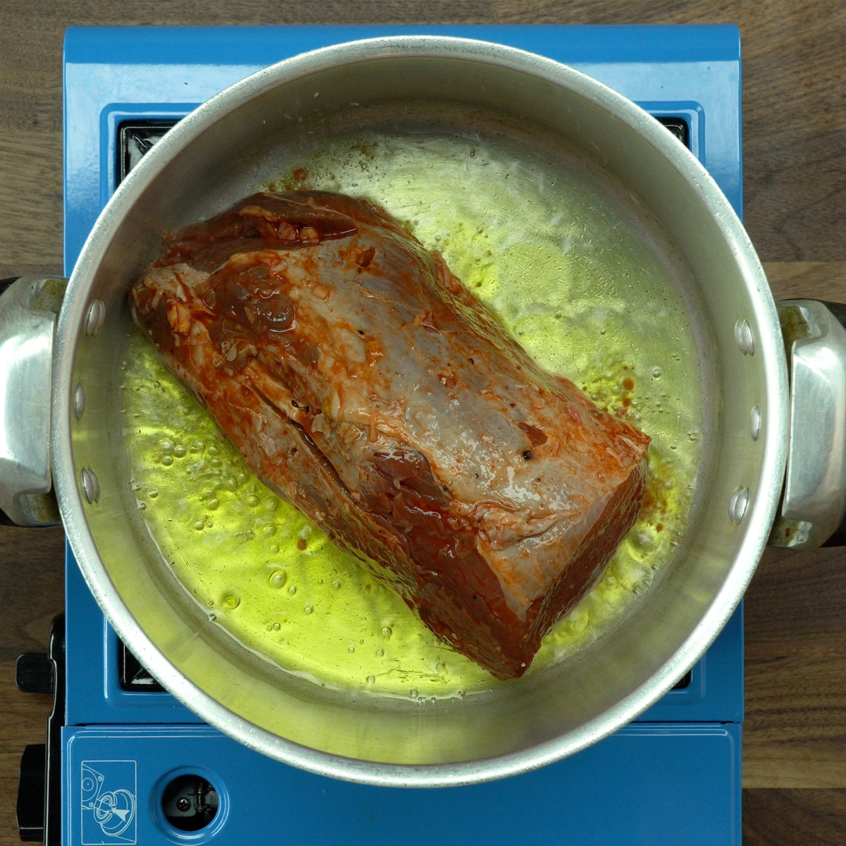 Lagarto sendo selado na panela de pressão com azeite.