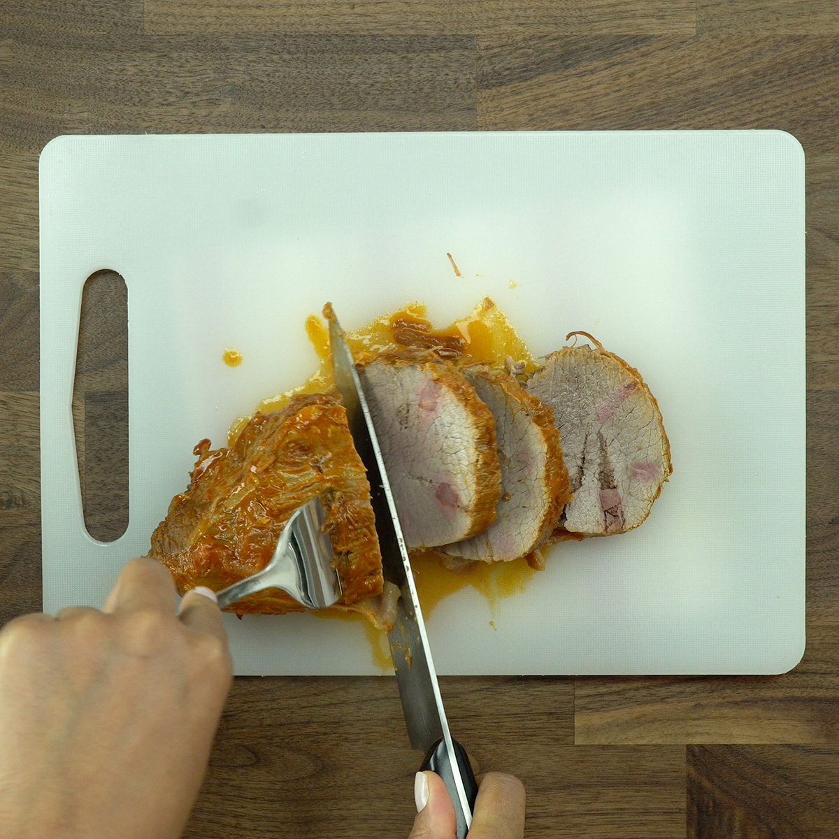 Lagarto cozido sendo fatiado em medalhões.