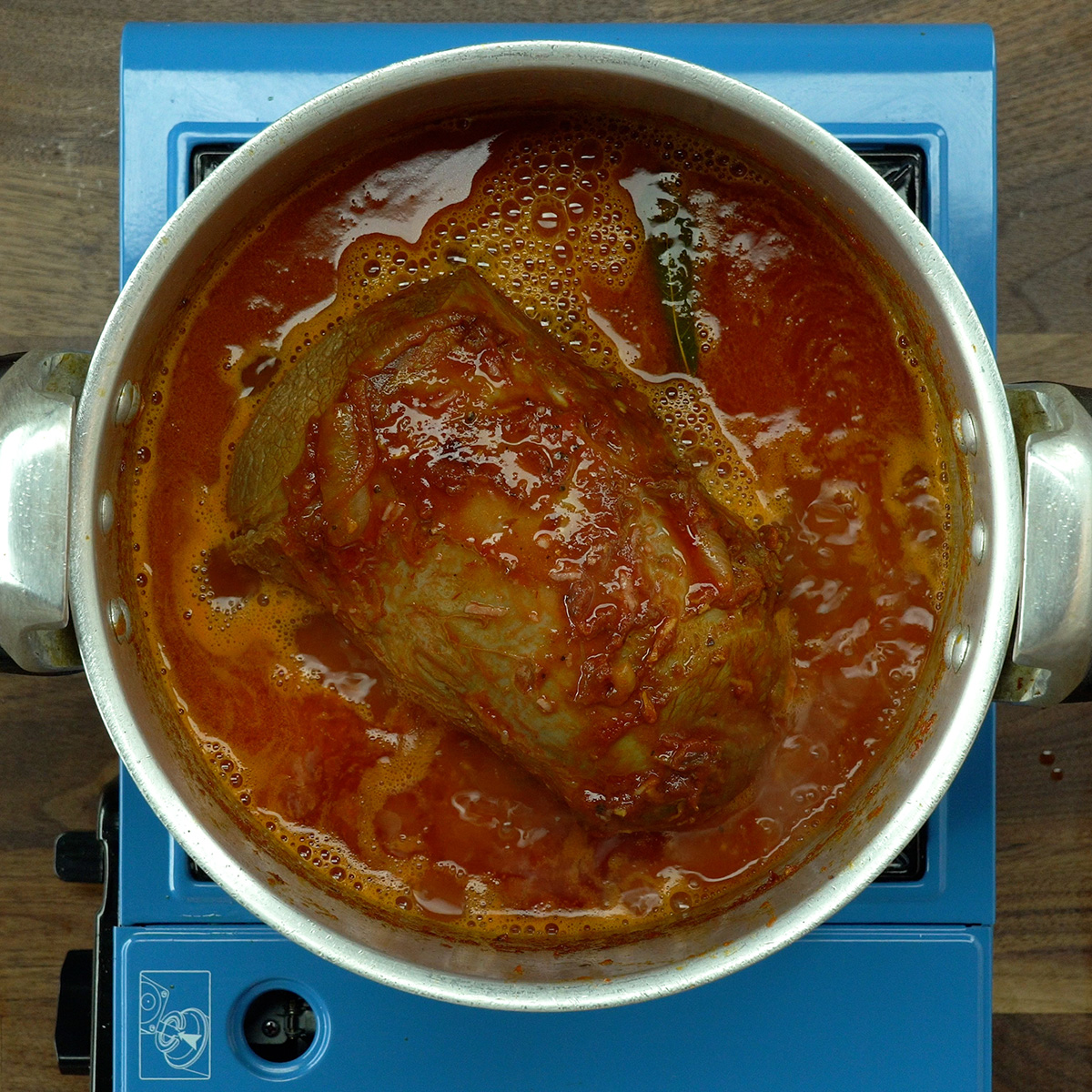 Lagarto na panela de pressão coberto com água e temperos.
