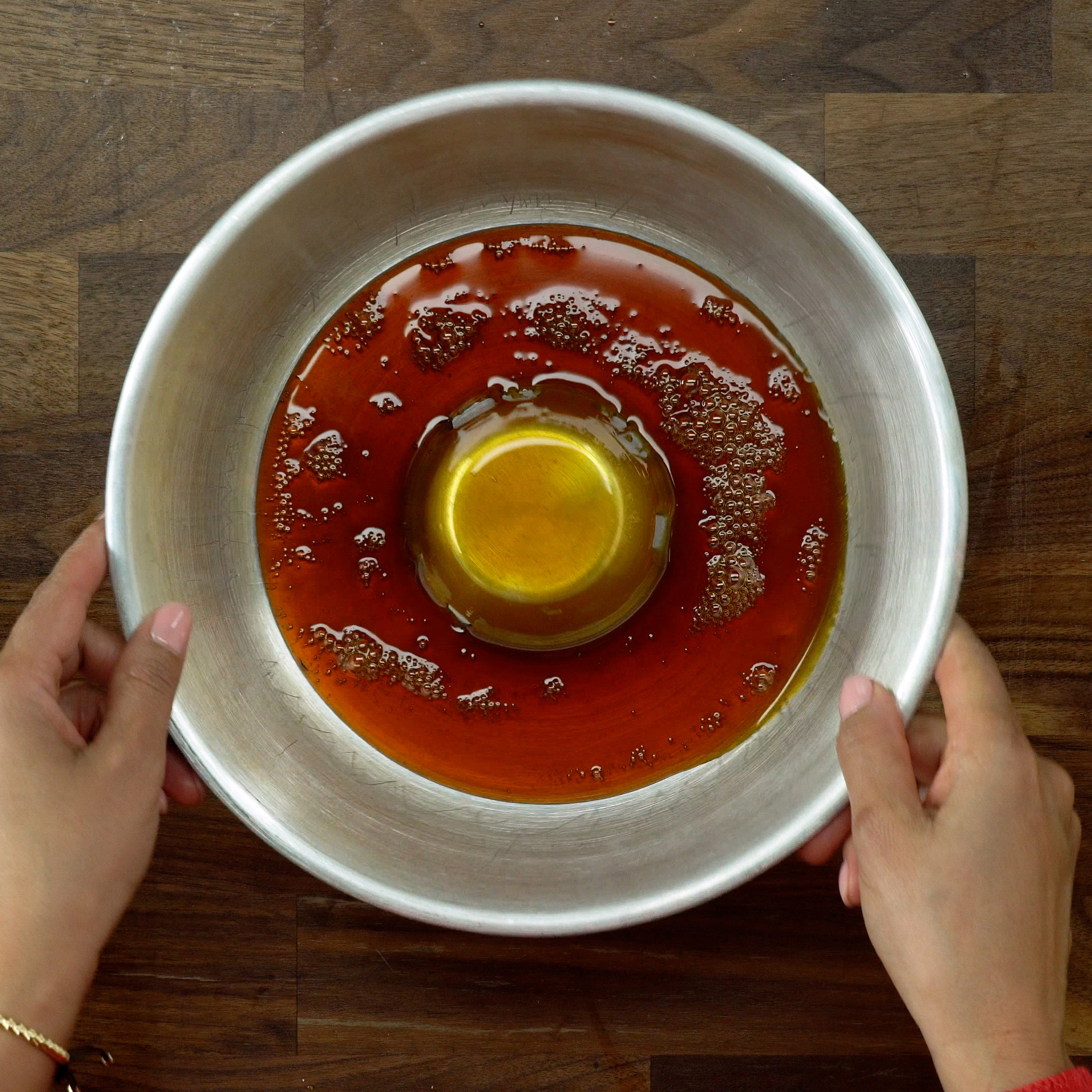 Espalhando a calda na forma de pudim.