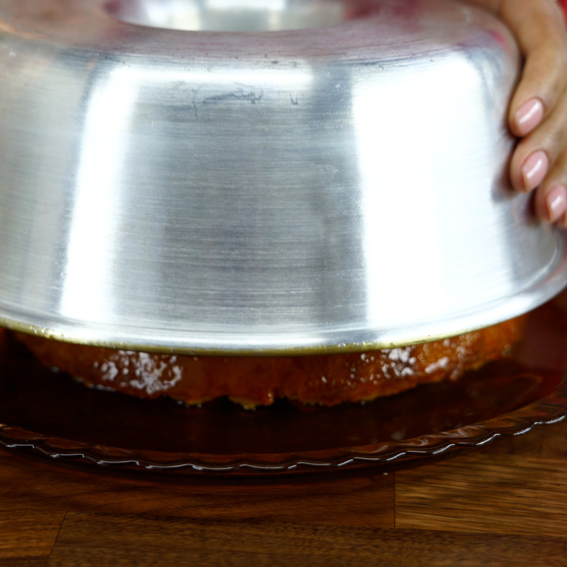 Pudim de pão de forma desenformado com a calda escorrendo.