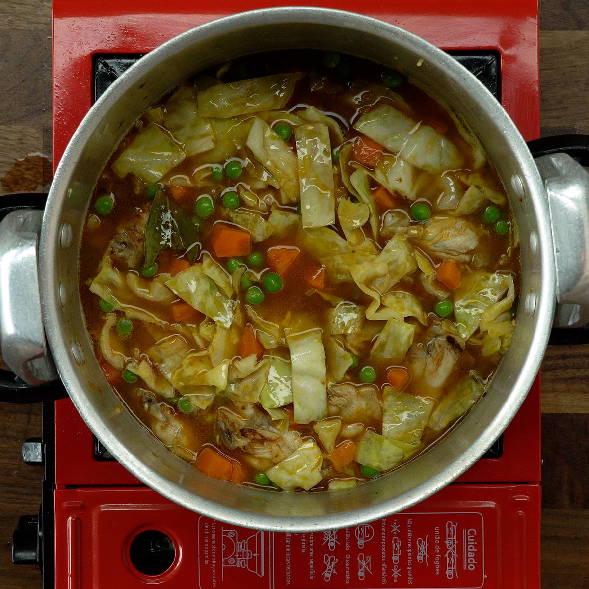 Panela de pressão com arroz, frango e legumes pronta para cozinhar.