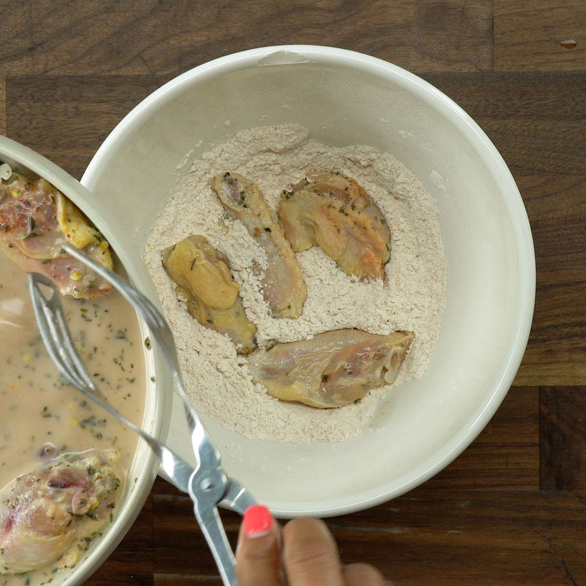 Empanando as asas de frango para serem fritas.