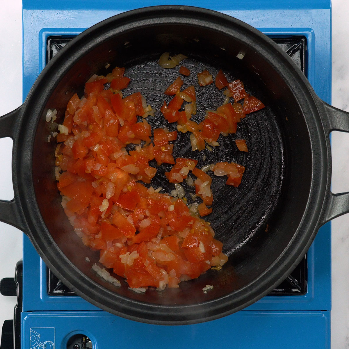 Cebola, alho, tomate e páprica refogando no azeite.