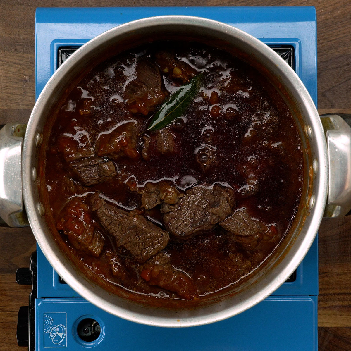 Adicionando polpa de tomate e vinho tinto à carne de panela.