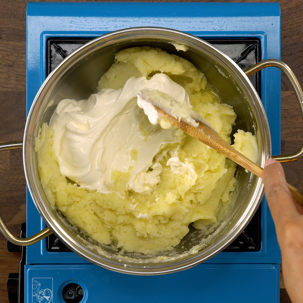 Purê de batata sendo misturado com manteiga e creme de leite.