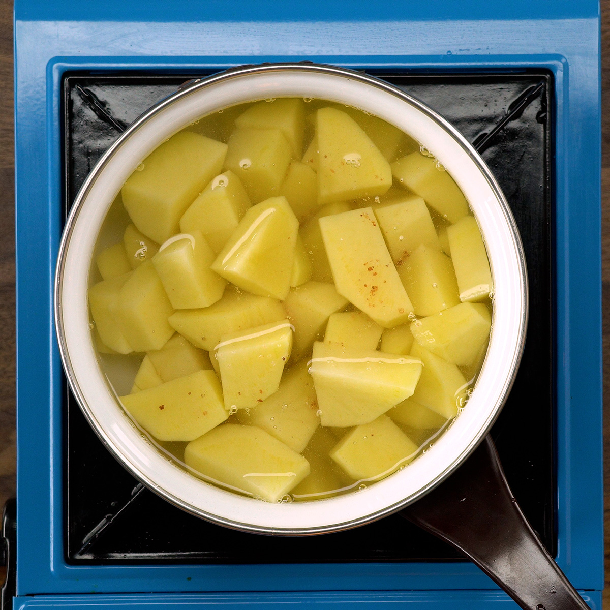 Batatas cozinhando em água com sal para o preparo do purê.