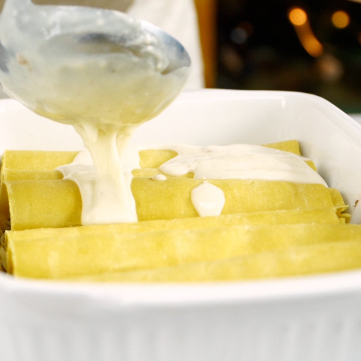 Adicionando molho branco sobre os canelones.