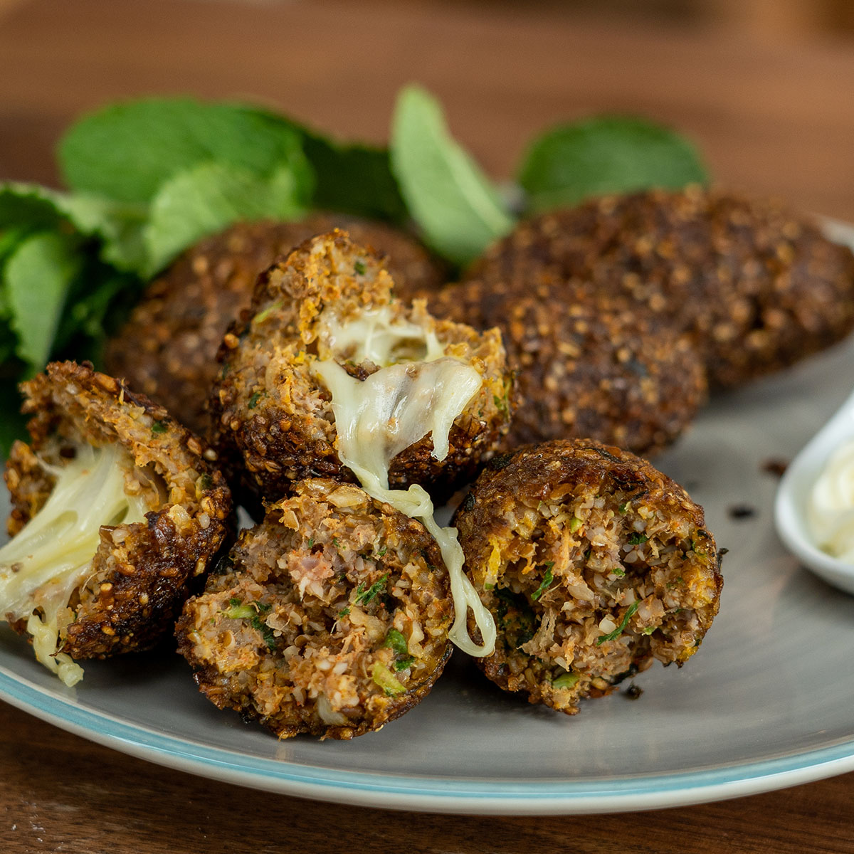Empratamento kibes recheados com queijo partido ao meio.