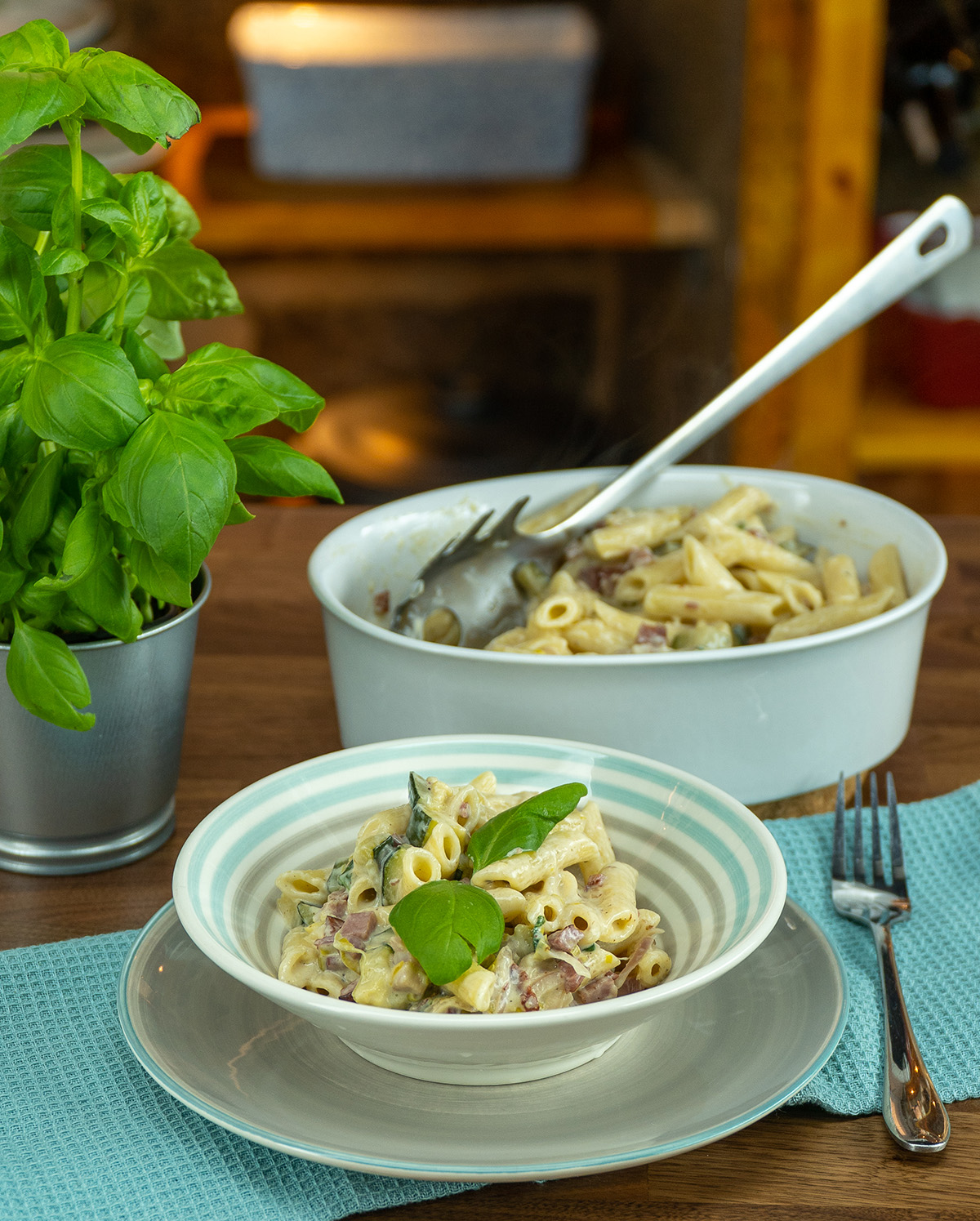 Penne com abobrinha, bacon e manjericão servido no prato.