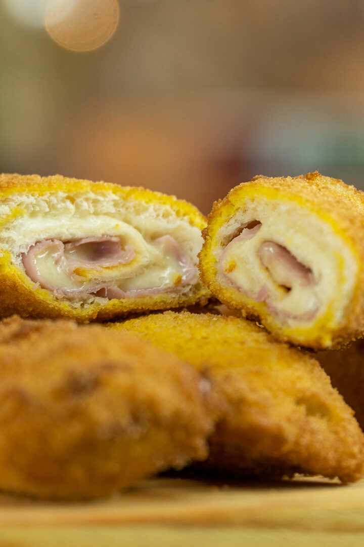 Empratamento salgadinho misto pão de forma cortado ao meio.