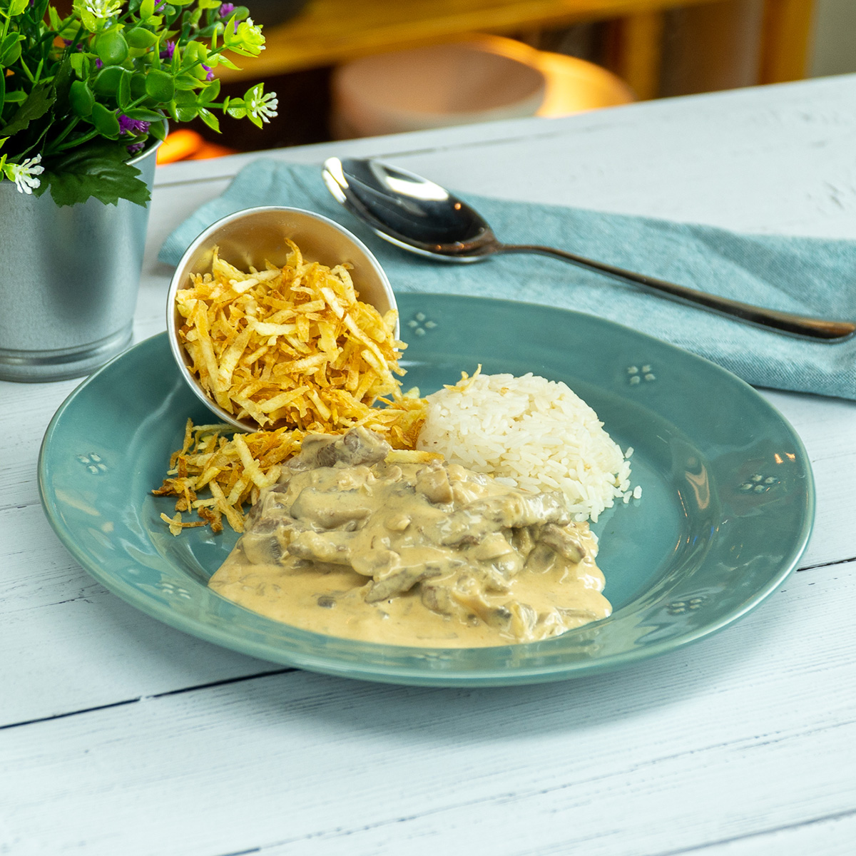 Estrogonofe de carne servido com arroz branco e batata palha.