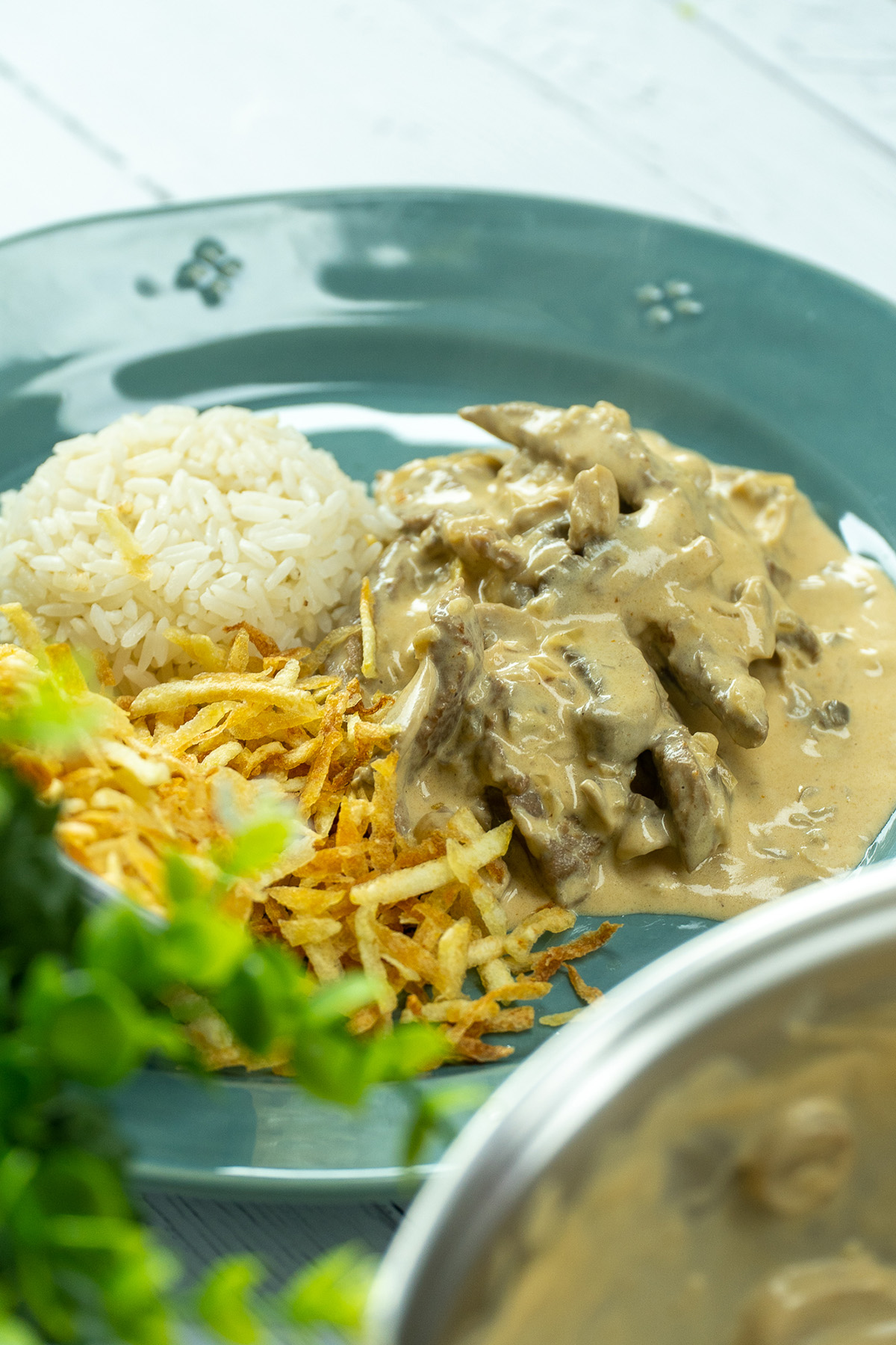 Estrogonofe de carne servido com arroz branco e batata palha.