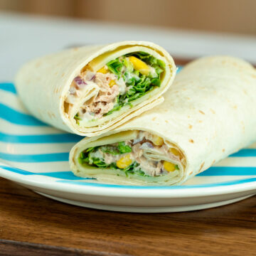 Empratamento wrap de atum servido cortado ao meio.