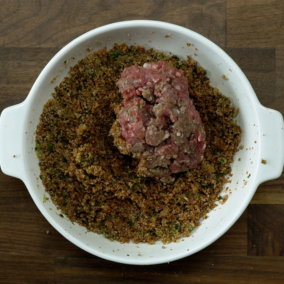 Carne moída sendo misturada à massa de kibe temperada.