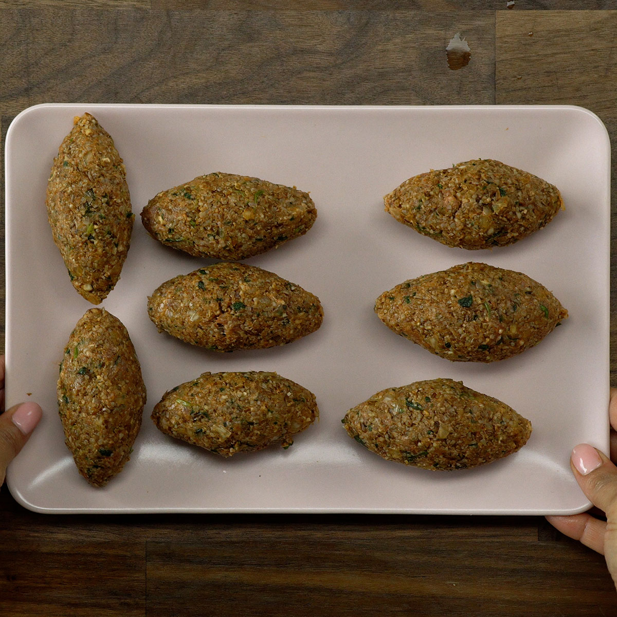 Kibes modelados sendo levados à geladeira antes da fritura.