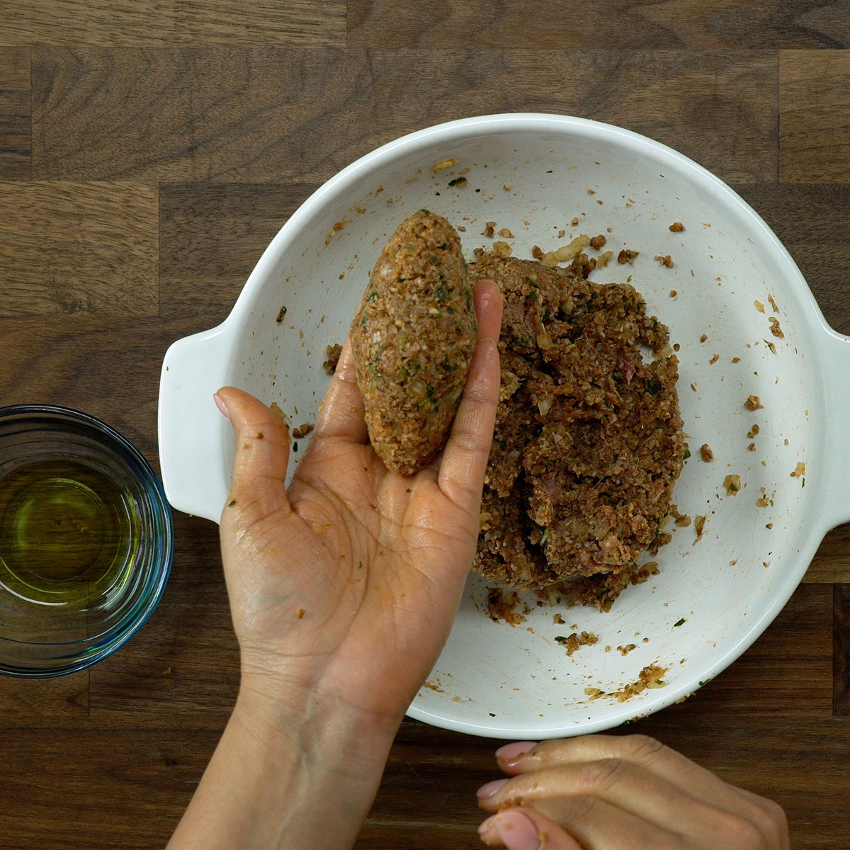 Kibe modelado sendo recheado com cubo de muçarela.