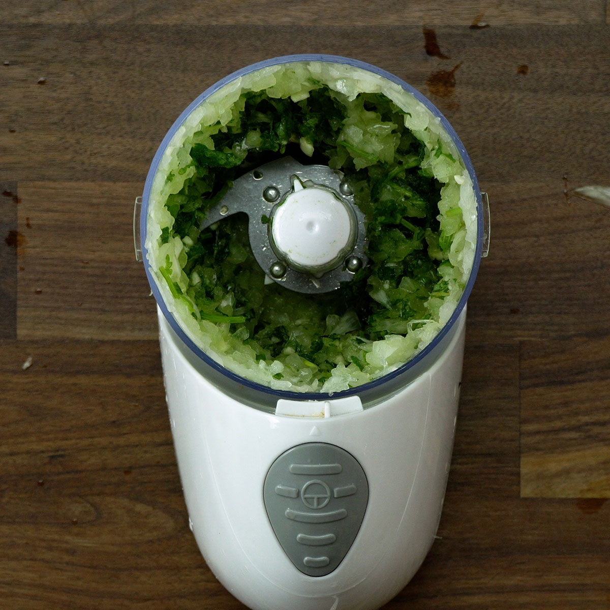 Cebola, alho e ervas sendo processados para preparar kibe frito recheado com muçarela.