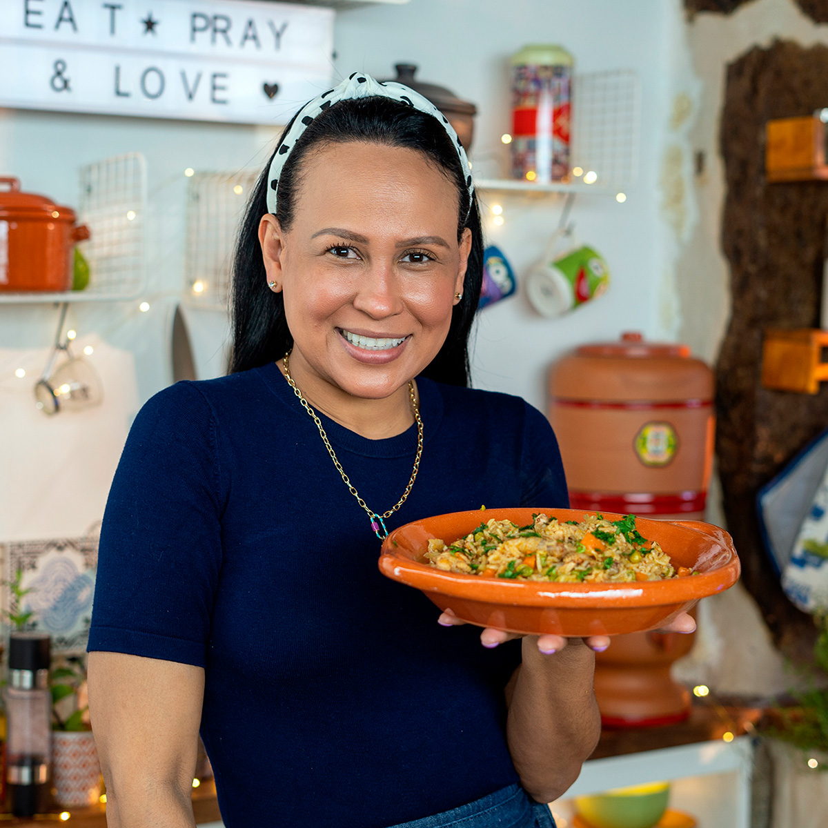 Mara Rodrigues segurando arroz com asinhas de frango.