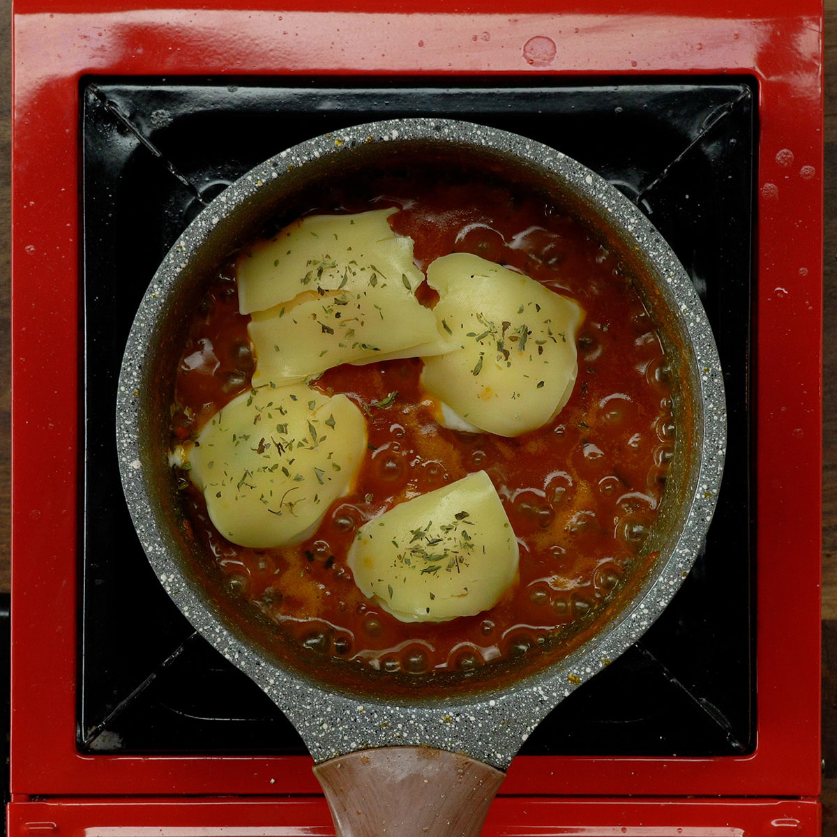 Ovos cobertos com queijo muçarela e orégano.