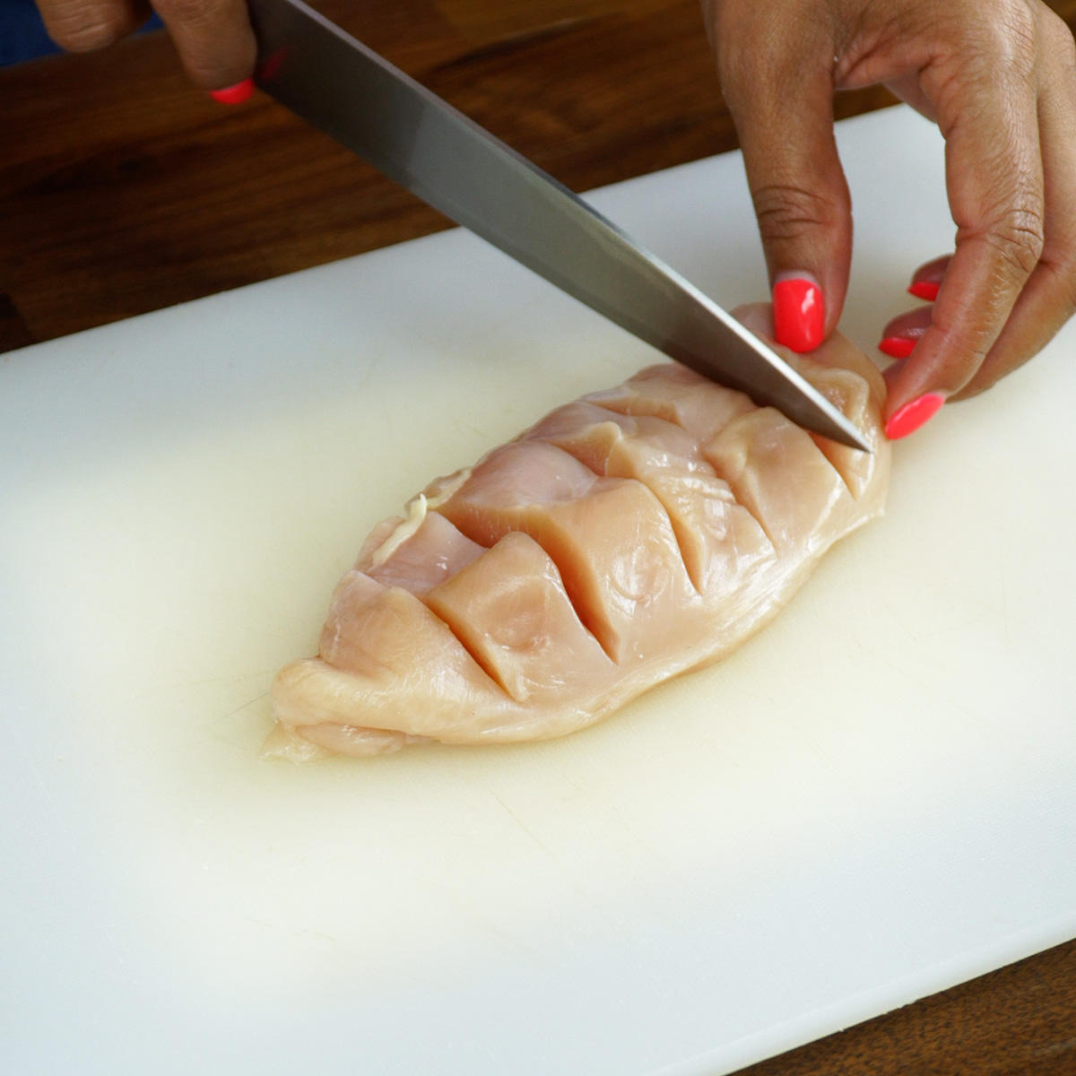 Peitos de frango crus com cortes profundos prontos para rechear.