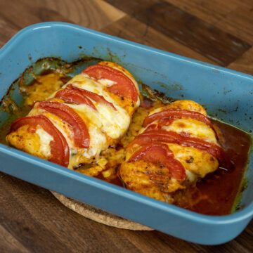 Peitos de frango recheados com tomate e mozzarella saindo do forno.
