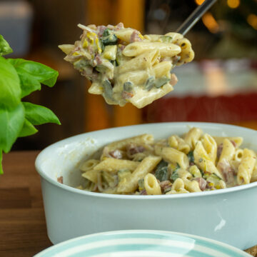 Penne com abobrinha e bacon sendo servido.