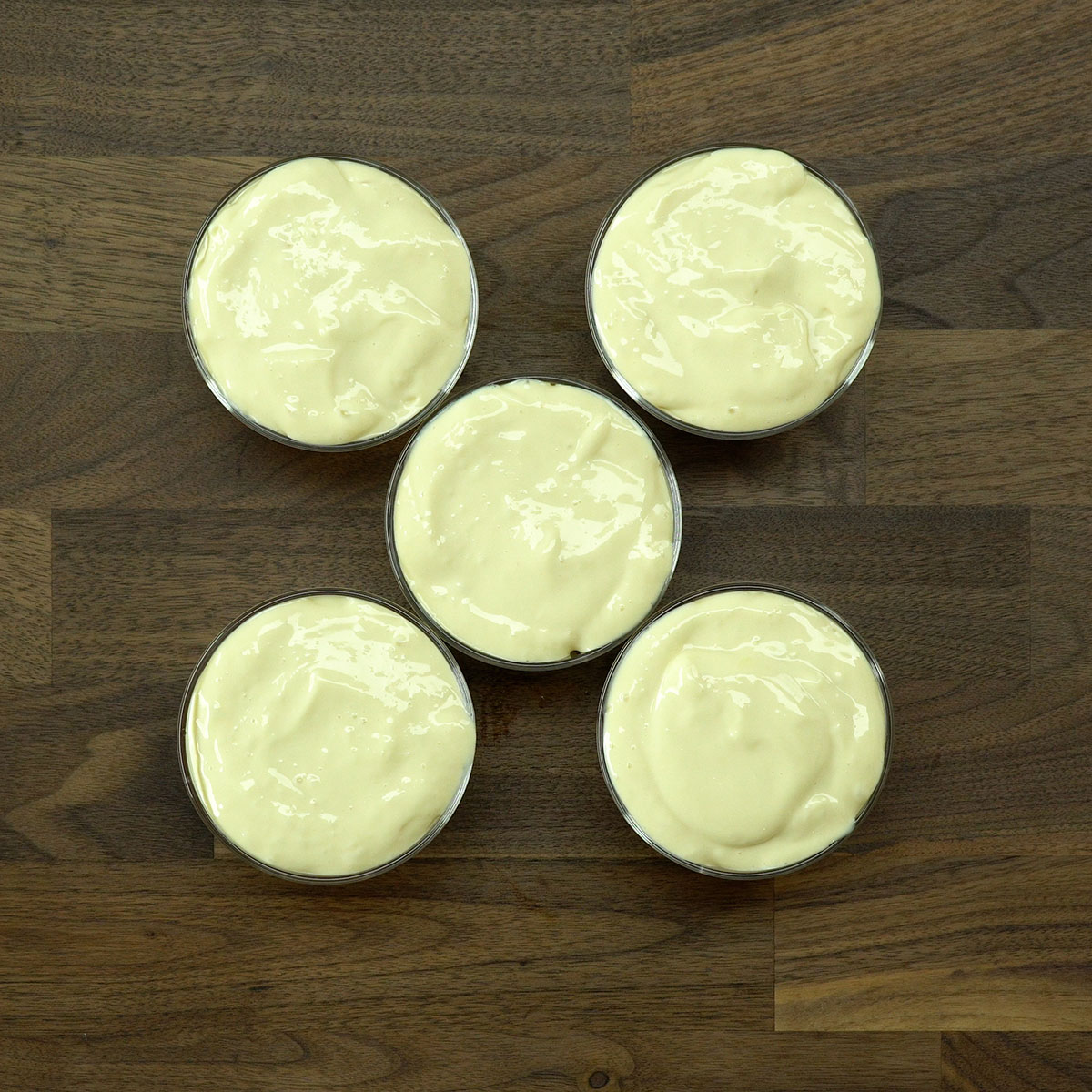 Mousse de maracujá sendo colocado sobre as frutas.