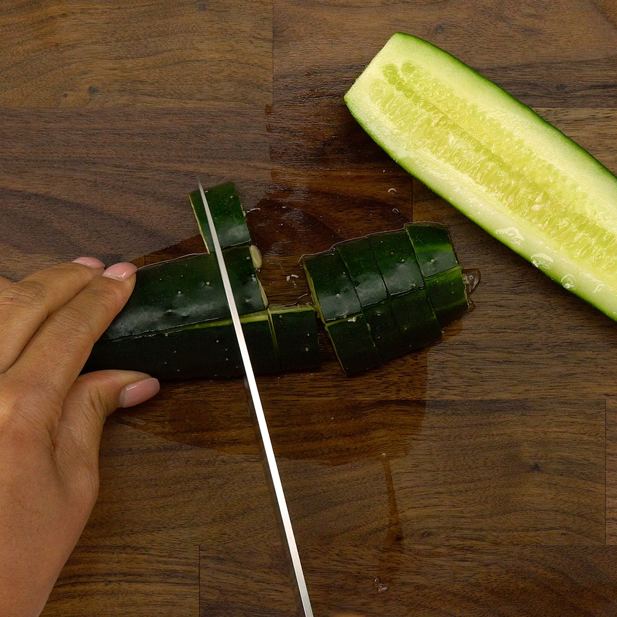 Pepino fresco sendo cortado em cubos pequenos.