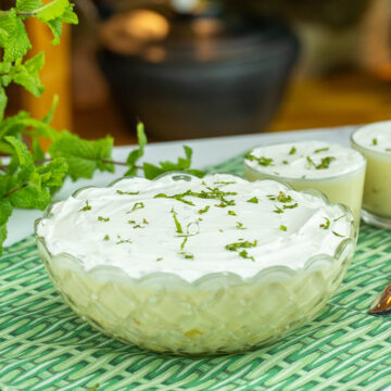 Sobremesa de abacaxi cremosa coberta com chantilly e decorada com hortelã picada.