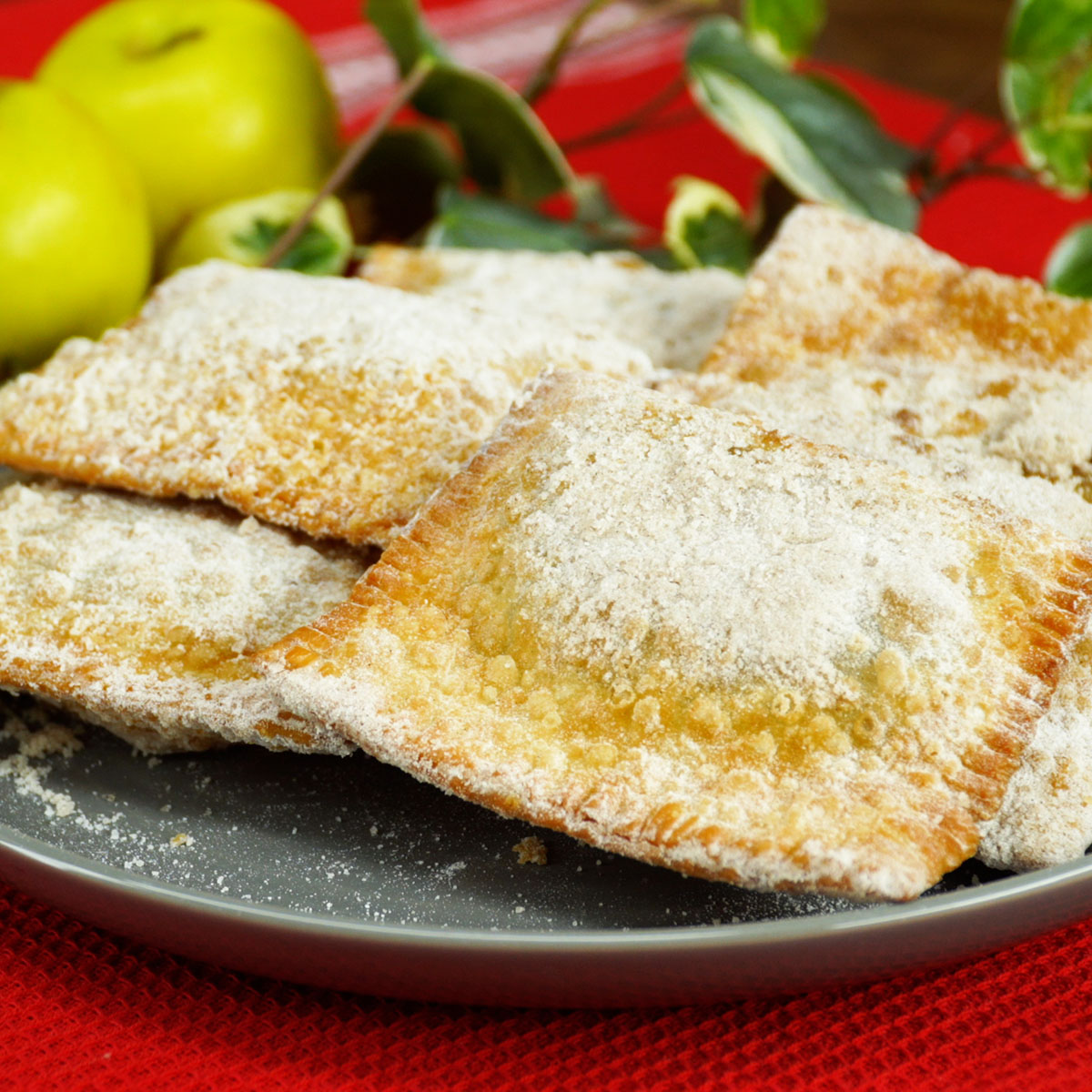 Tortinhas de maçã fritas finalizadas com açúcar e canela.