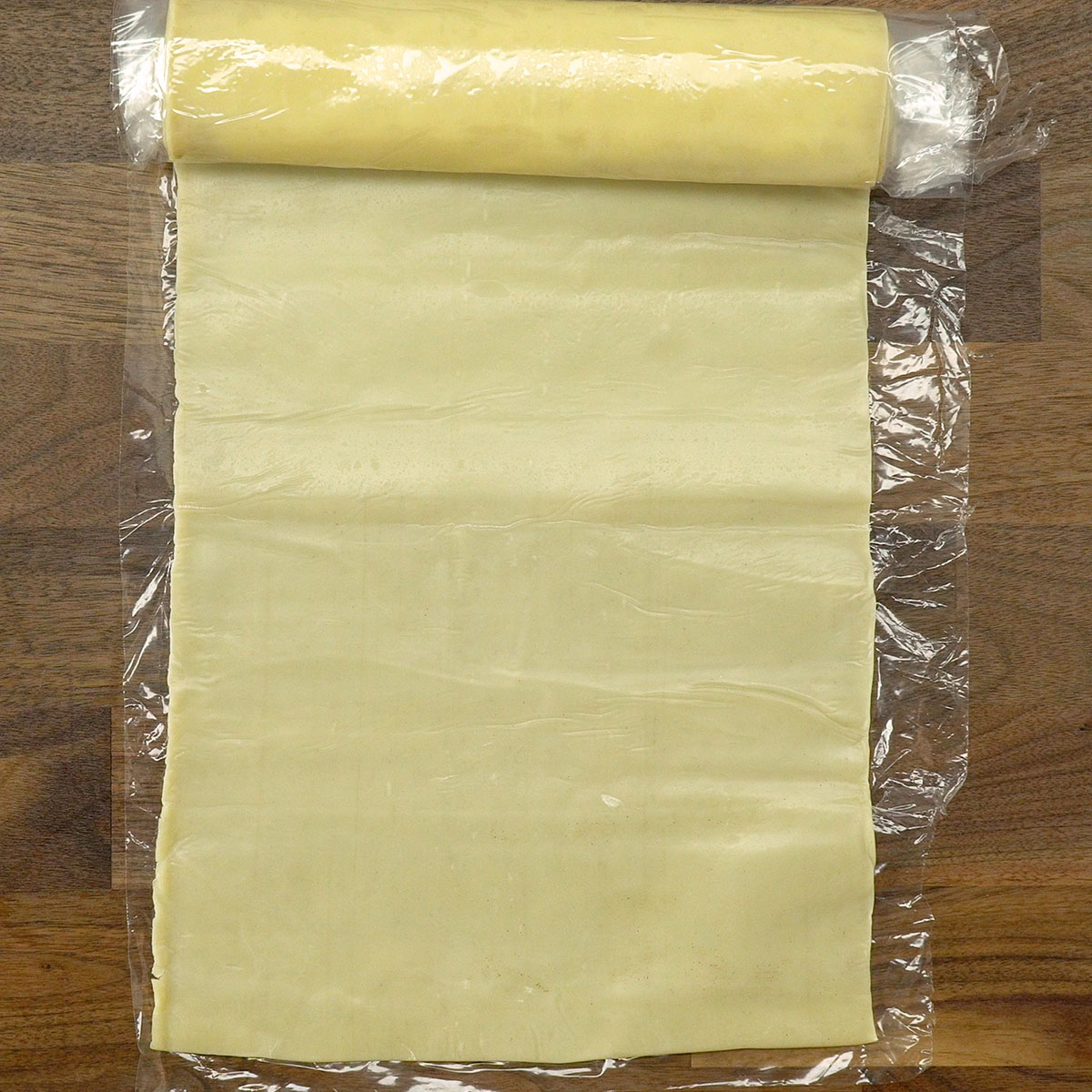 Massa de pastel aberta para modelar as tortinhas de maçã fritas.