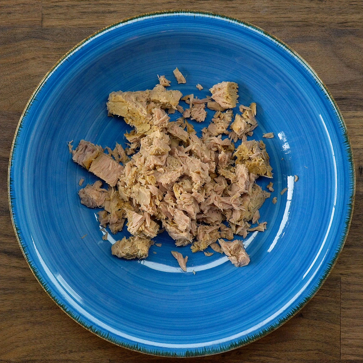 Atum escorrido e solto no prato, pronto para ser temperado.