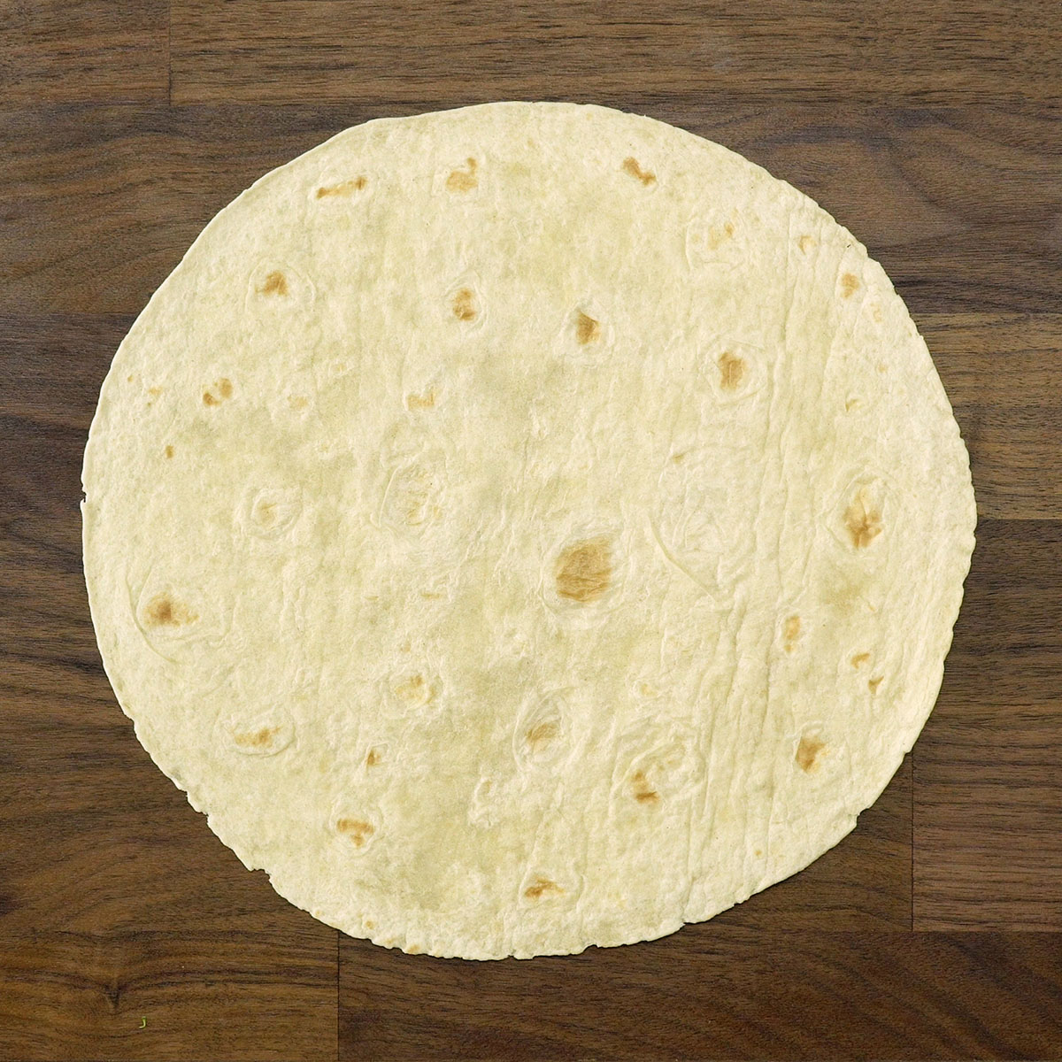 Massa de wrap aberta na bancada, pronta para receber o recheio.