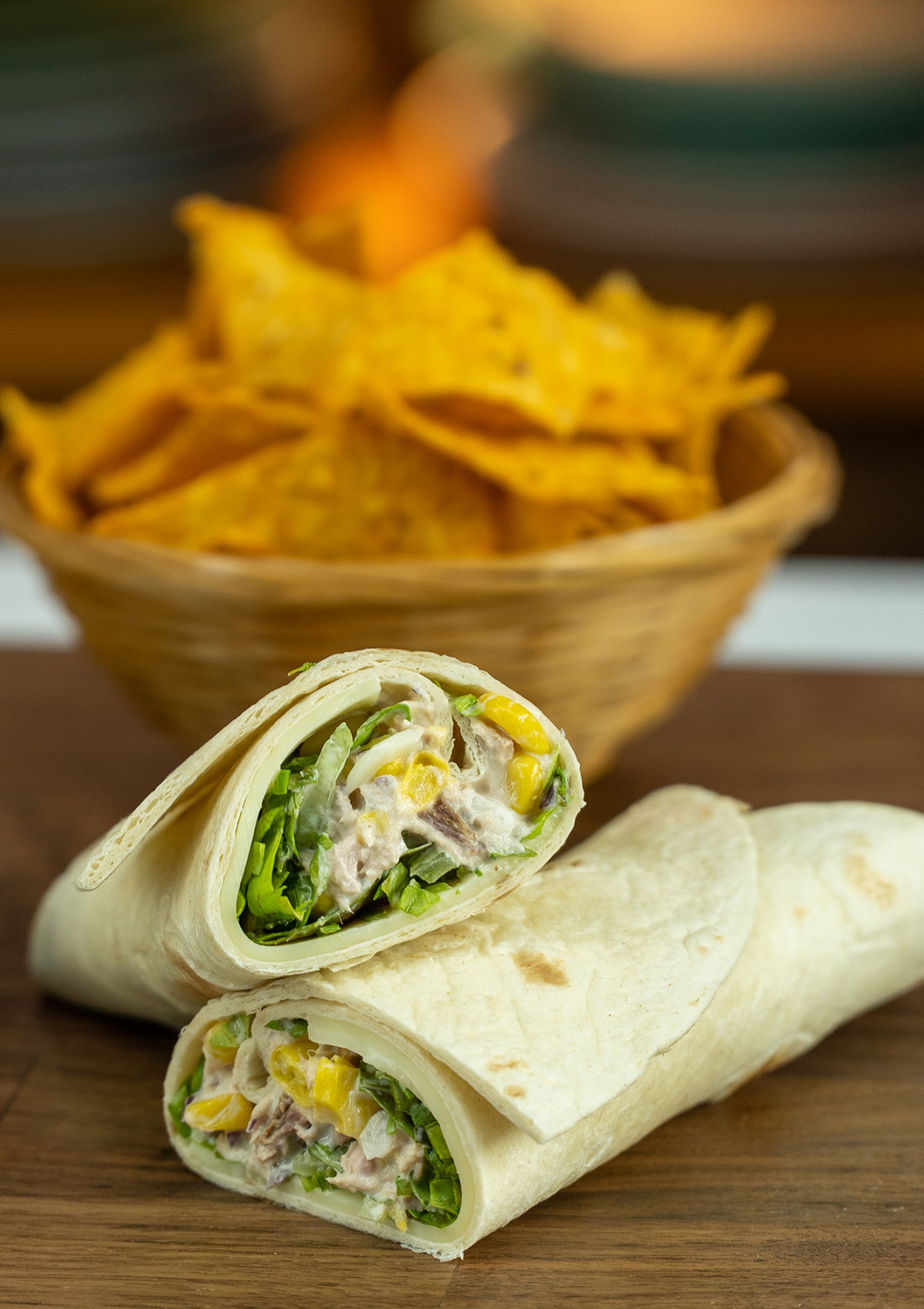 Wrap de atum cortado ao meio com Doritos de acompanhamento.