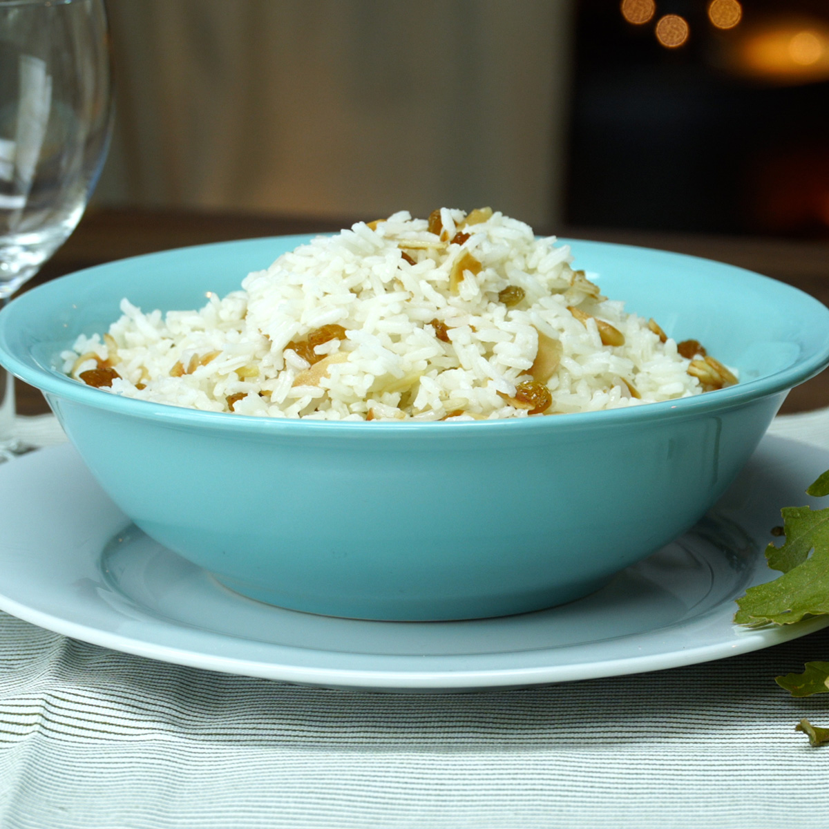 Arroz com sultanas e amêndoas sendo transferido para uma tigela.