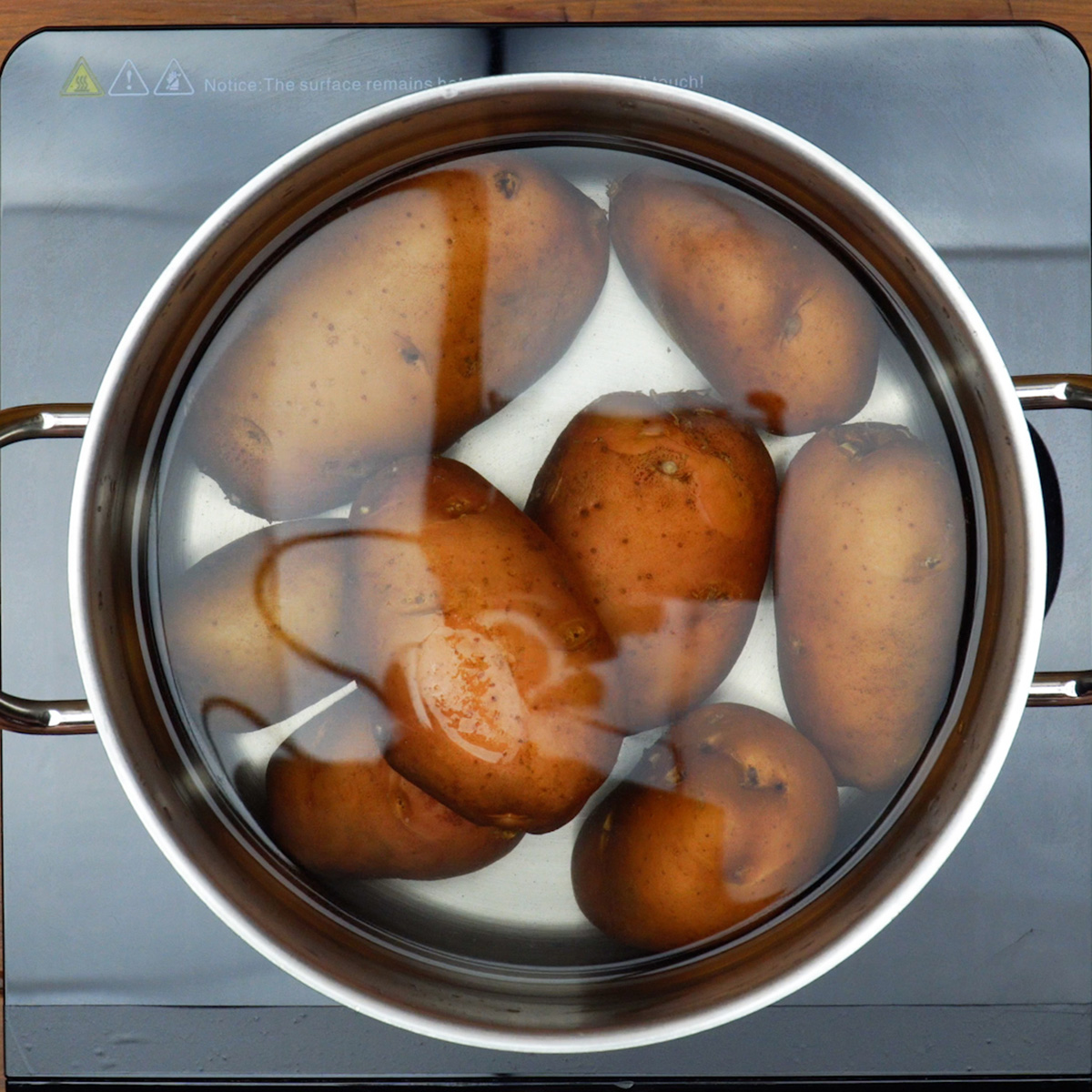 Batatas cozinhando na panela para preparar o purê.