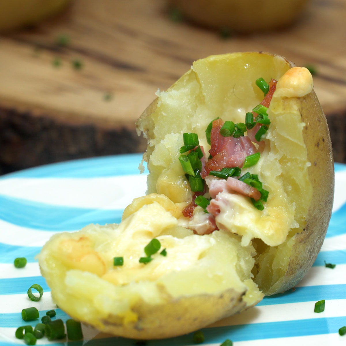 Batata recheada com bacon e queijo finalizada com cebolinho.