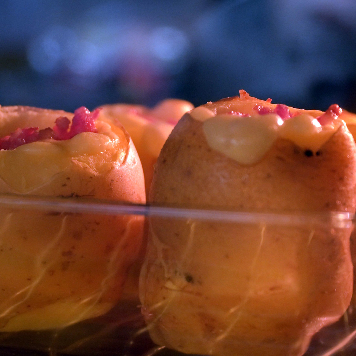 Batatas recheadas com bacon e queijo assando no forno até dourar.