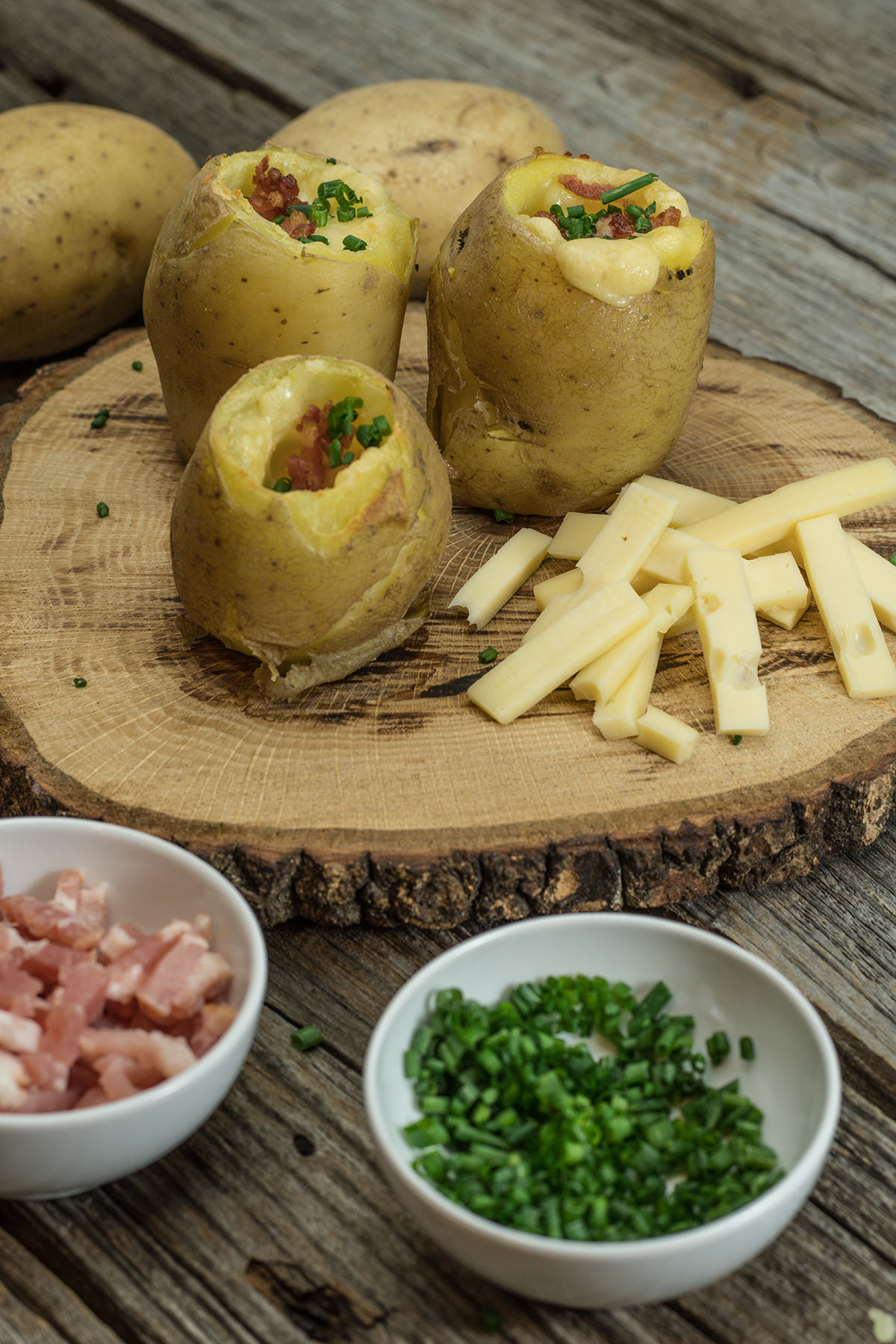 Batata recheada com bacon e queijo finalizada com cebolinho.