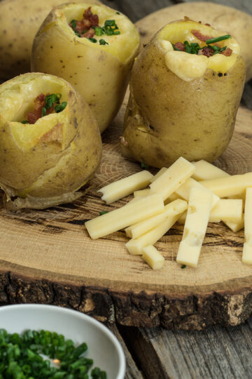 Batata recheada com bacon e queijo finalizada com cebolinho