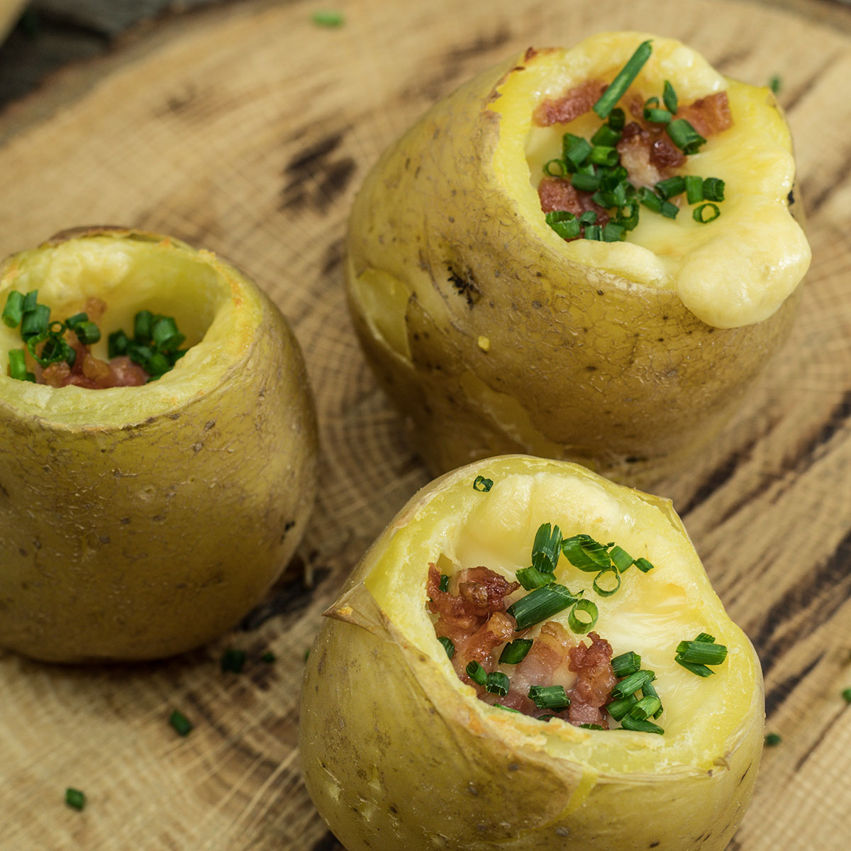 Batata recheada com bacon e queijo finalizada com cebolinho.