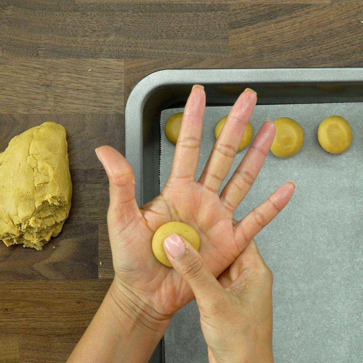 Bolinhas de massa pressionadas com o dedo e organizadas em forma com papel-manteiga.