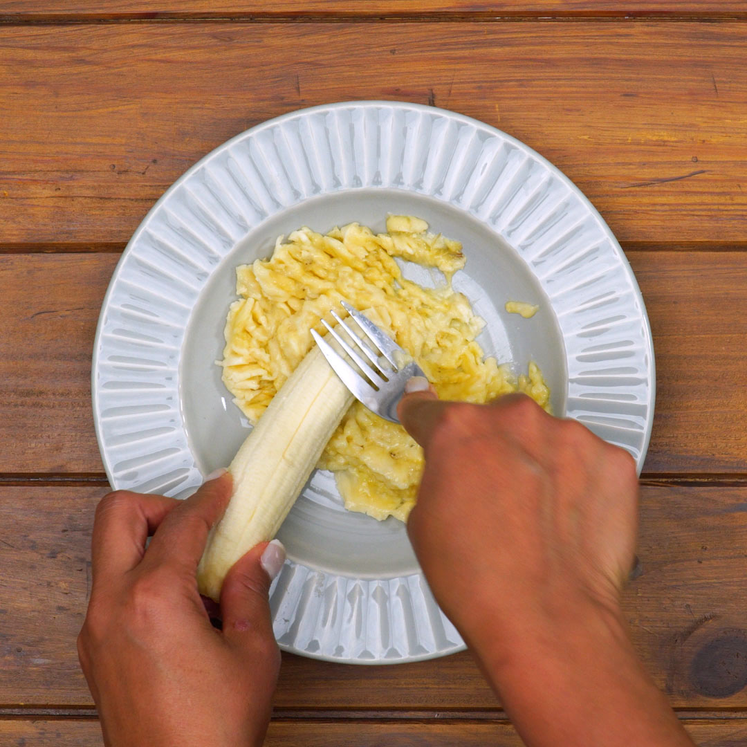 Bananas amassadas e bananas em rodelas para preparar bolo de banana.