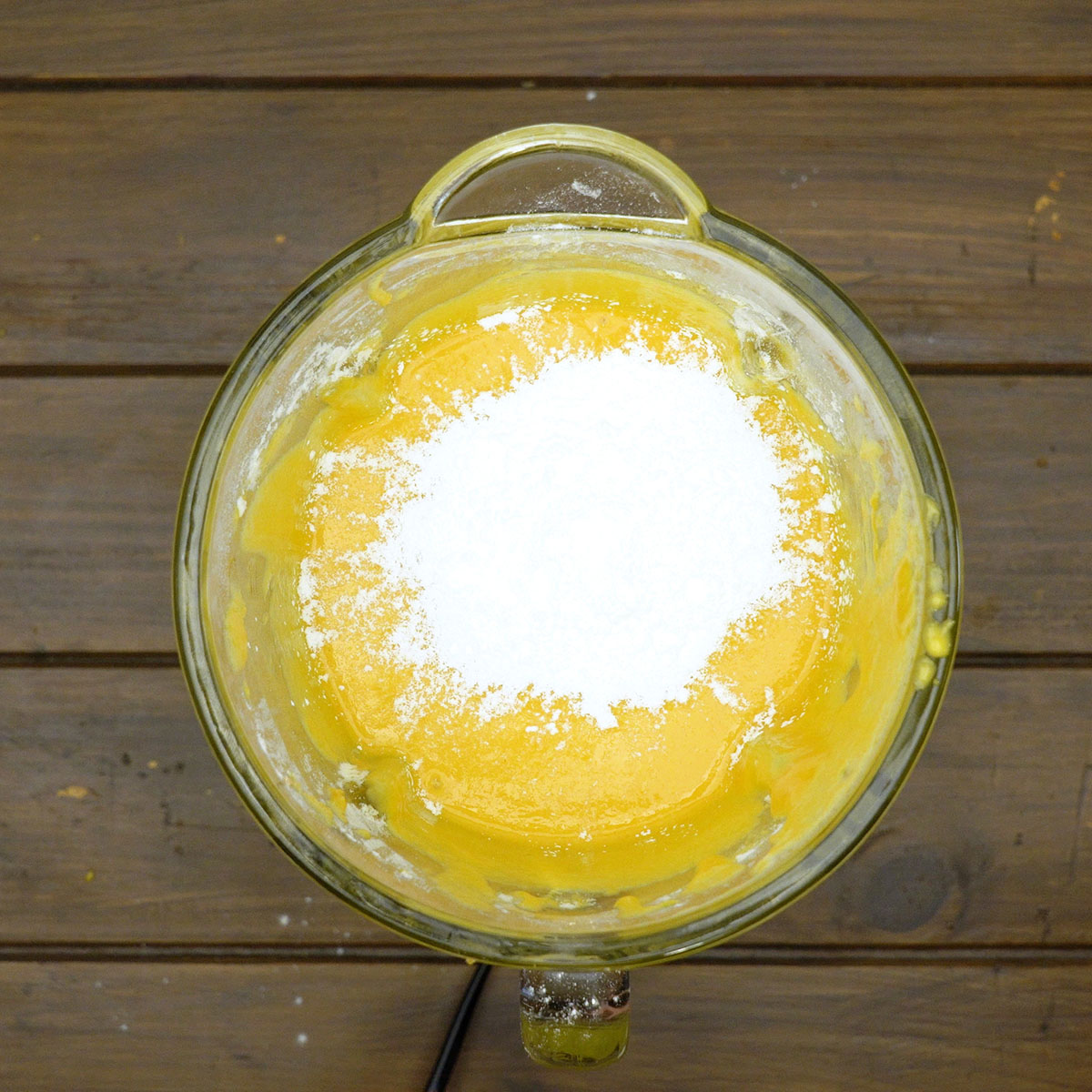 Fermento em pó e sal sendo incorporados à massa do bolo.