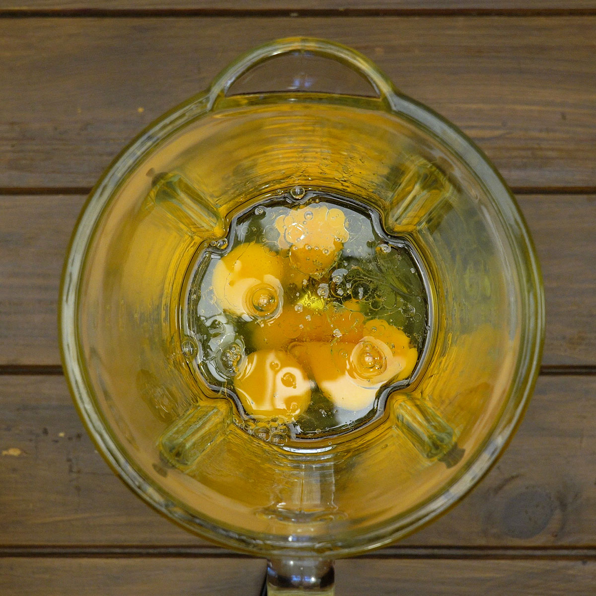 Ovos e óleo sendo batidos no liquidificador até formarem uma mistura homogênea.